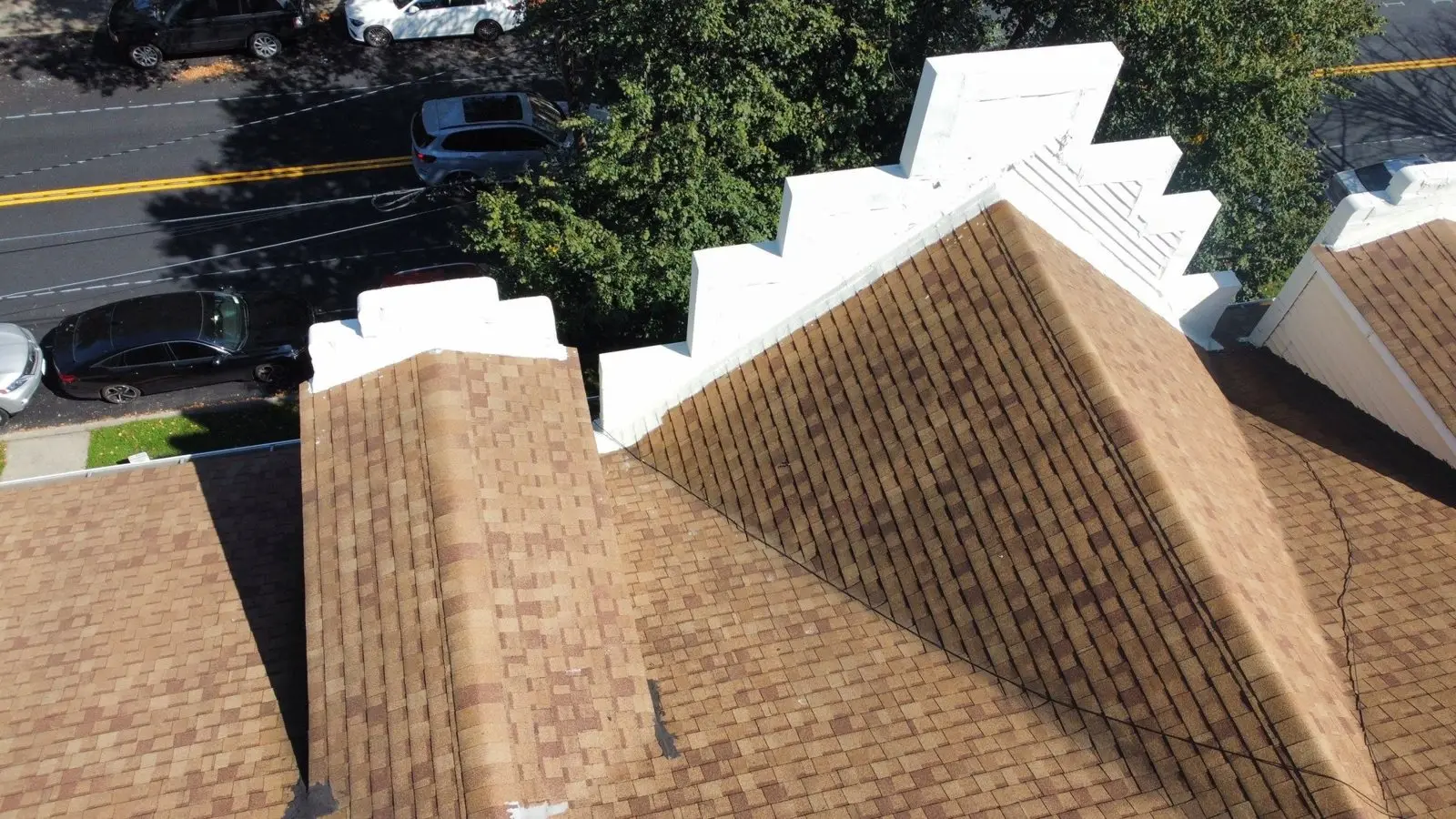 Close drone view of shingle roof ridges and parapets on a condo building