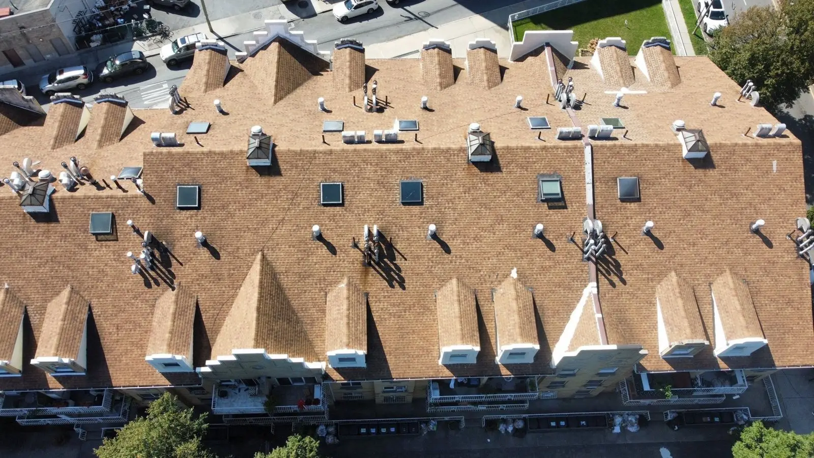 Drone photo of a long multifamily condo building roof with many dormers in Staten Island