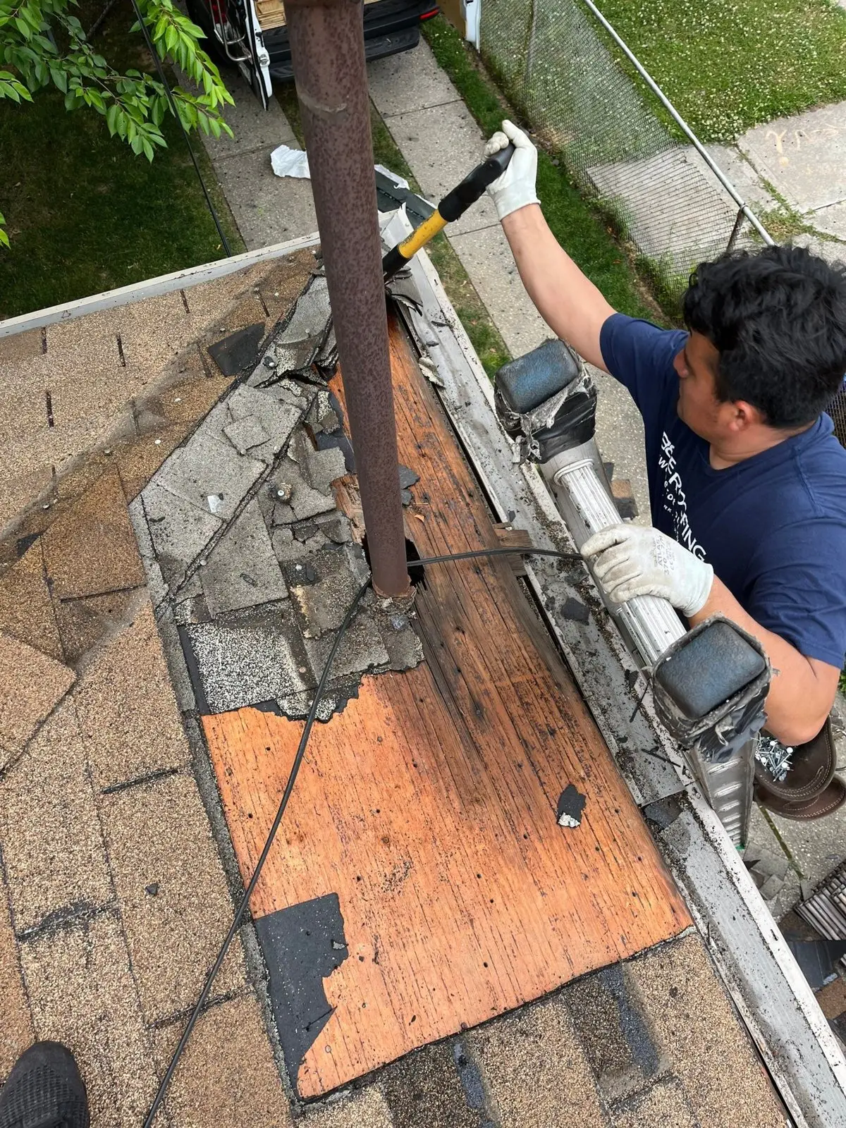 Roofer repairing a leak around a vent pipe