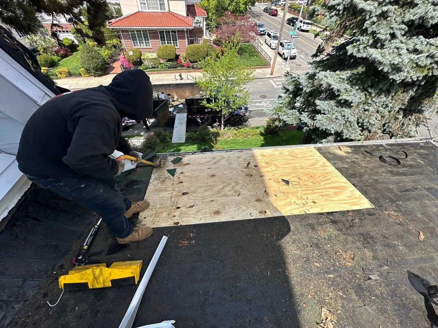 Roofer repairing the deck of a flat roof with new plywood before new membrane