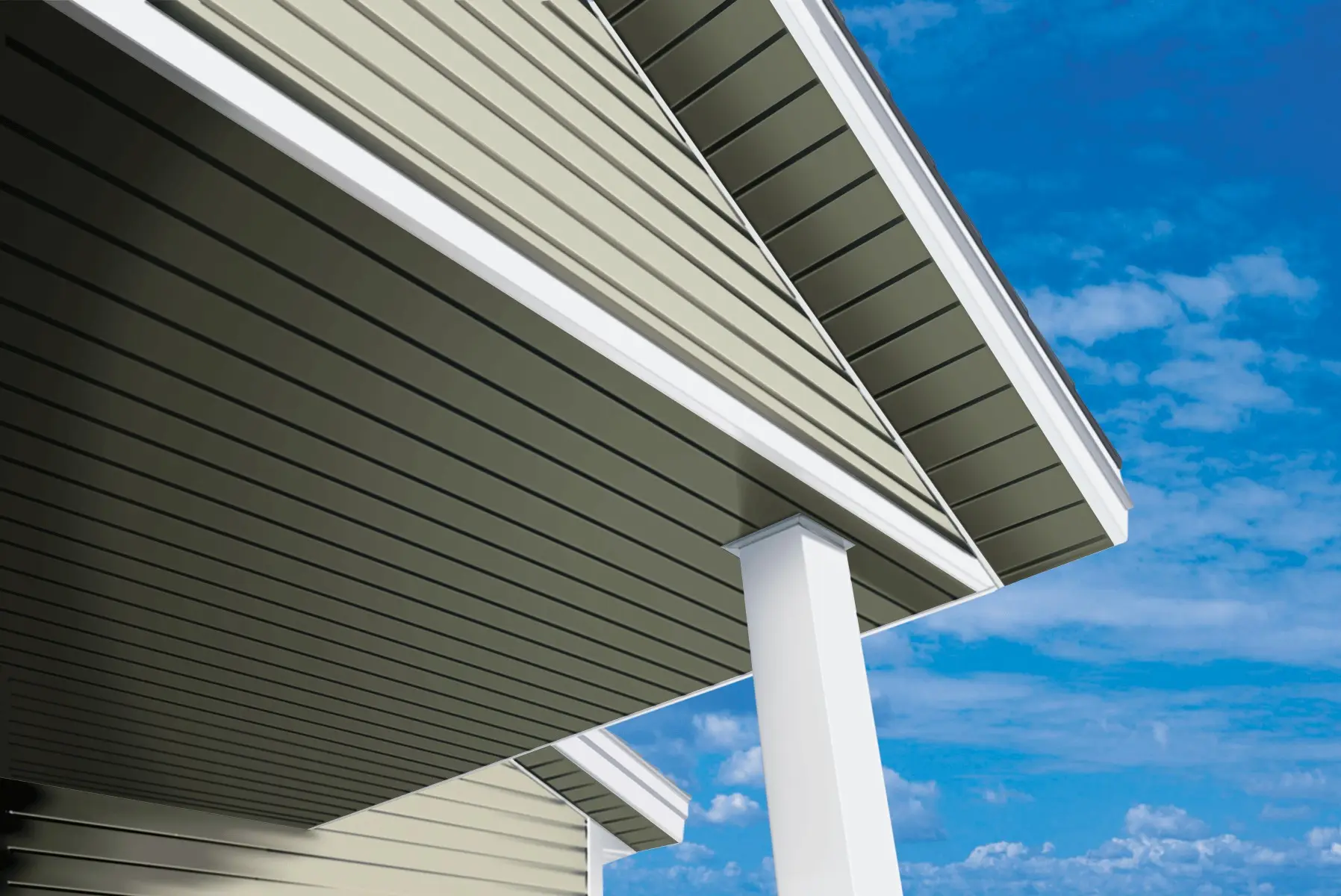 New siding and white soffit under a roof overhang against a blue sky