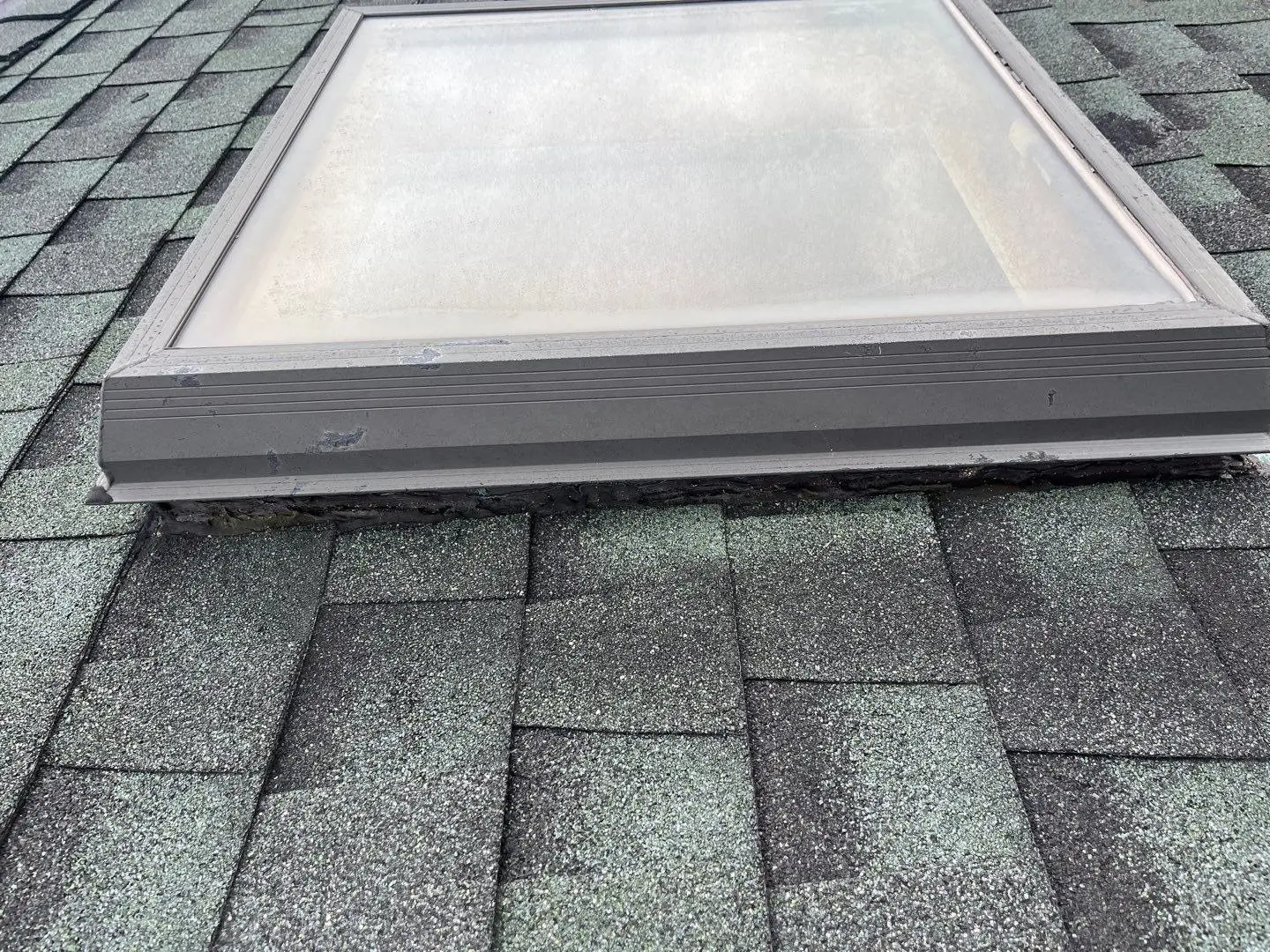 Skylight curb and frame on a shingle roof up close