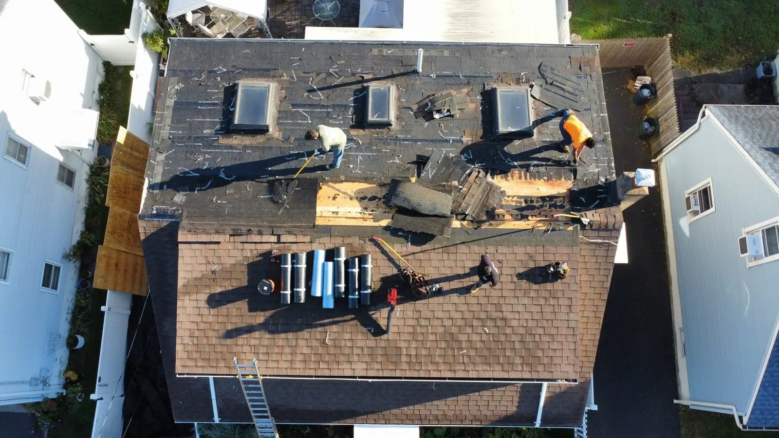 Drone photo of three skylight openings during a roof replacement