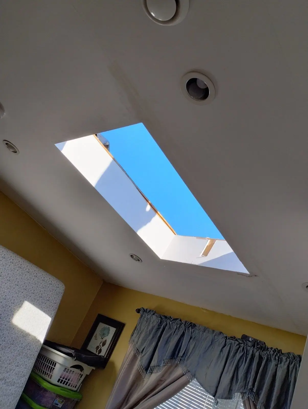 Bright ceiling with a new skylight showing blue sky inside a home