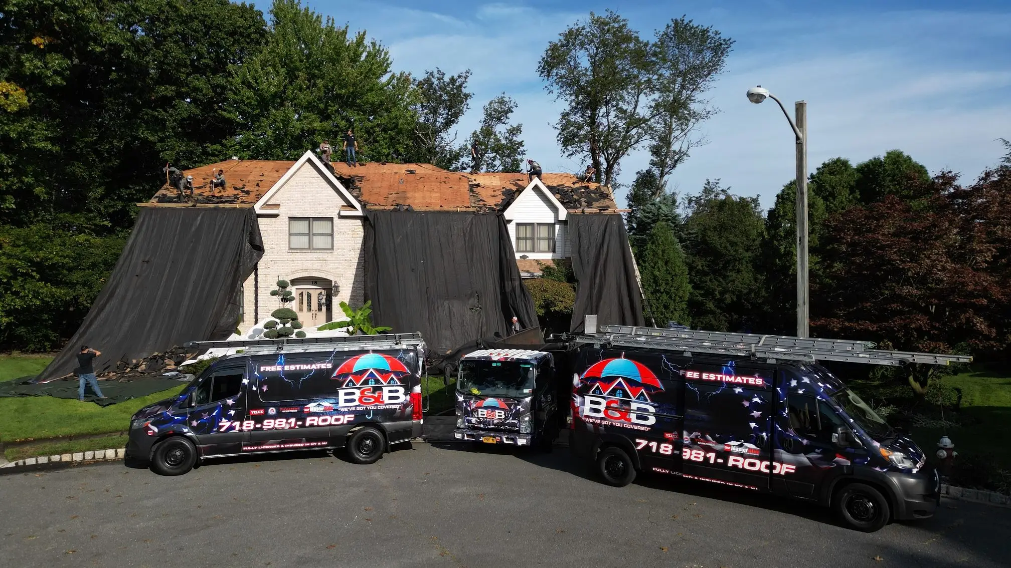 Two B&B Roofing trucks parked at a home during a roof replacement