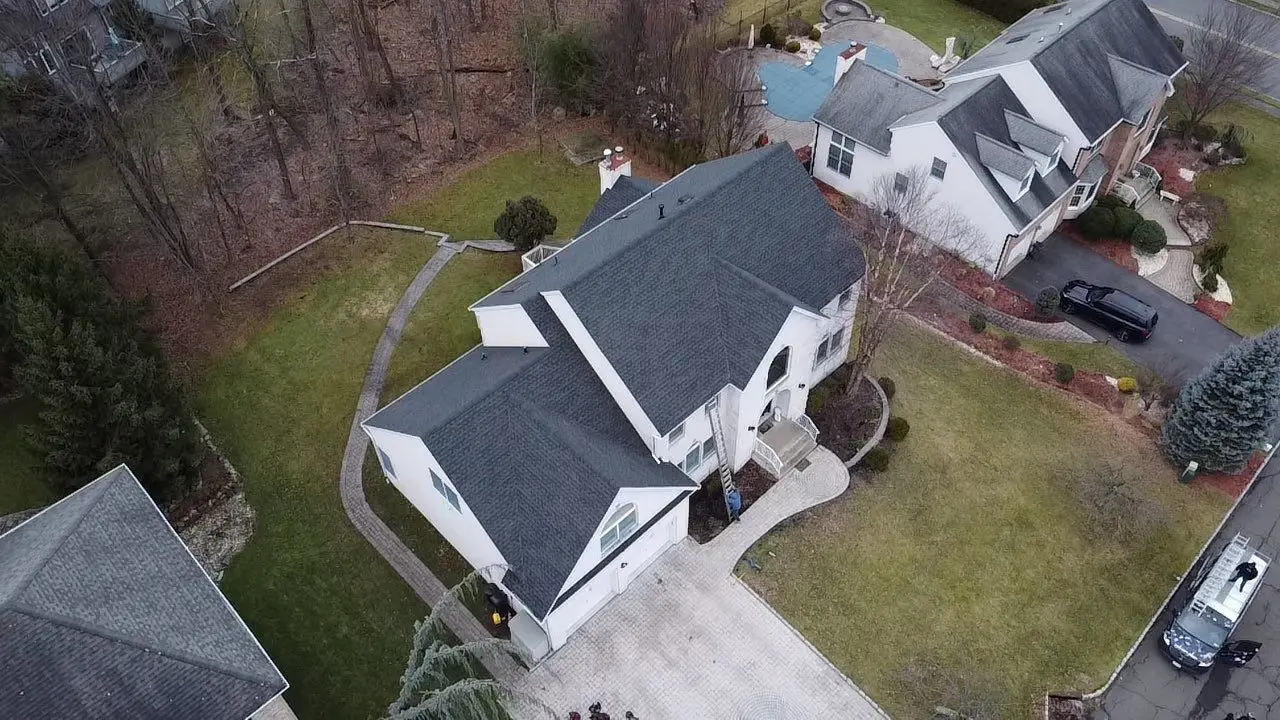 Drone photo of a white house in Wayne, NJ, with a new dark shingle roof